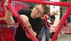 Eine Mitarbeiterin des stillgelegten Fahrradwerkes «Bike Systems» in Nordhausen beklebt am Montag den Rahmen des so genannten «Strike Bike». (Foto: dpa)