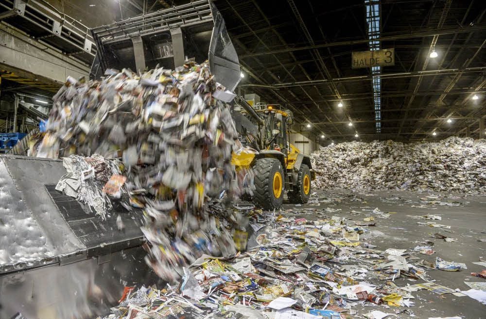 Am Anfang steht das Altpapier, das per Radlader auf Bänder geladen wird (l.).