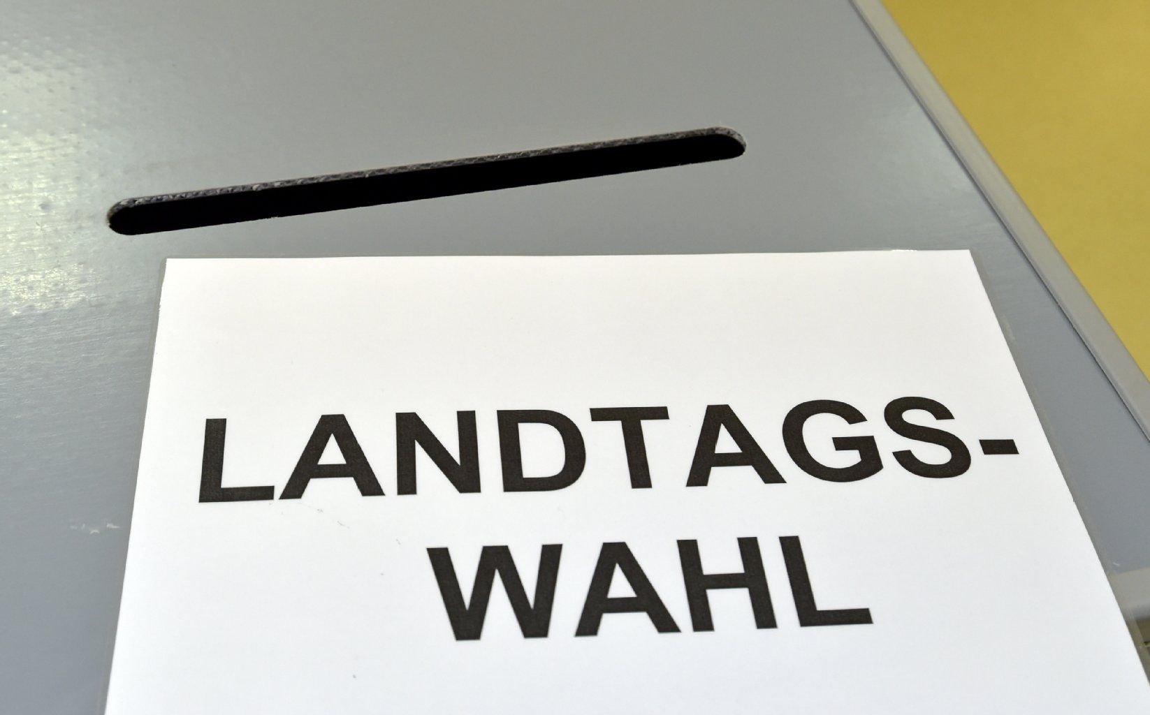 Ein Zettel mit der Aufschrift Landtagswahl liegt auf einer Wahlurne in einem Wahllokal.