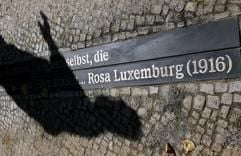 Ein Passant betrachtet am Donnerstag (14.09.2006) auf dem Rosa-Luxemburg-Platz in Berlin ein in das Pflaster eingelassenes Spruchband mit Zitaten von Rosa Luxemburg. (Foto: dpa)