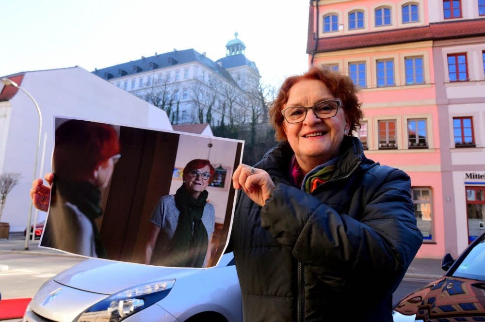 Sabine Manschatz zeigt vor der Kulisse des Schlosses ihr Selbstporträt, das in der Fotoausstellung gezeigt wird.