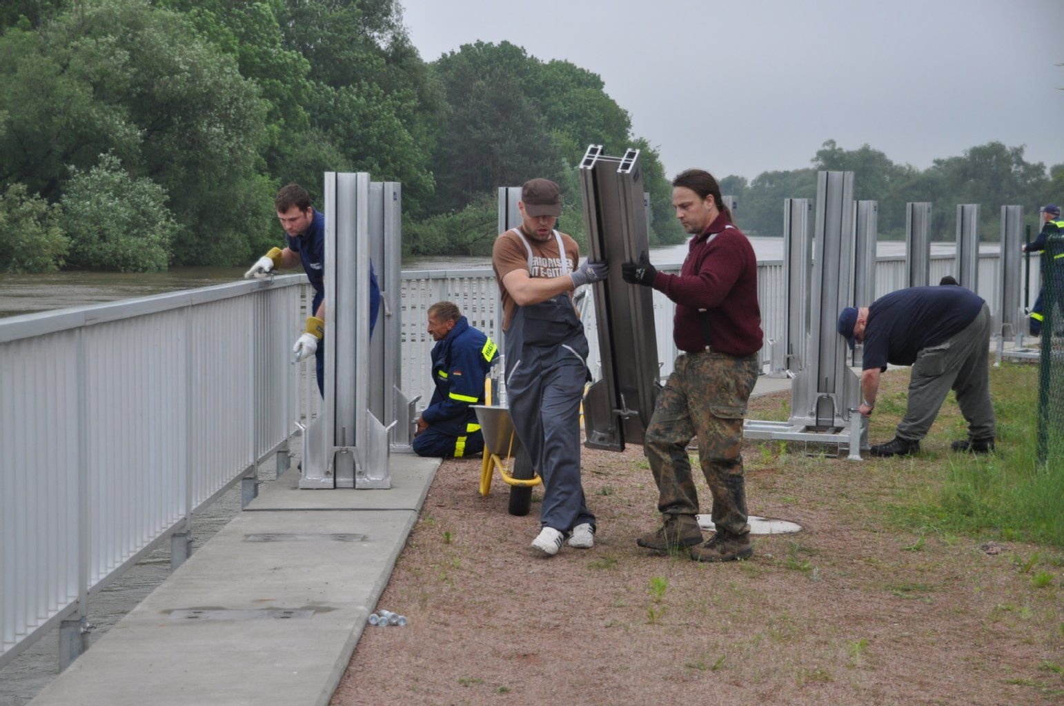 In Jeßnitz bauen Mitarbeiter der Wasserwehr die mobile Spundwand an der Mulde auf.