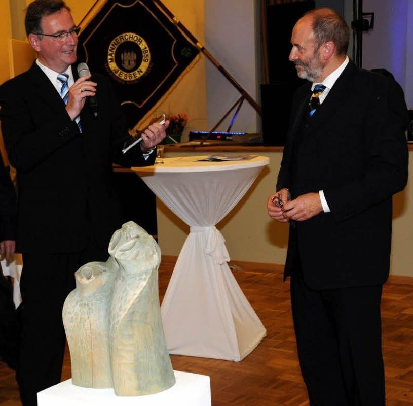 Volker Oertel (li.) verabschiedet Udo Sommer nach 30 Jahren musikalischer Leitung. Im Vordergrund die Skulptur von Klaus Kuhrmann.