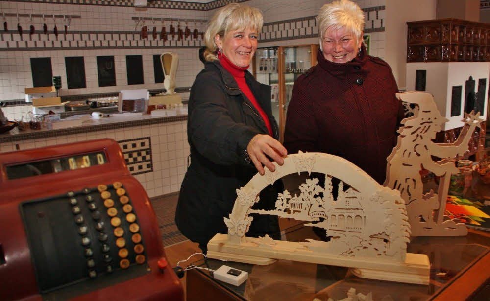 Heidi Müller und Heidemarie Liedtke (r.) schauen sich im Krämerladen um. Die Schwibbögen wurden vom Schulförderverein Benndorf gebaut.