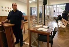 Ein Justizbeamter steht kurz vor Verhandlungsbeginn gegen den mutmaßlichen Kindermörder Marc Hoffmann im Landgericht Stade vor der transparenten Wand aus Panzerglas, die das Gericht und den Angeklagten von dem Publikum abschirmt. (Foto: dpa)