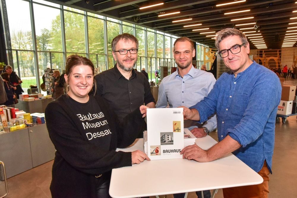 Die ersten Exemplare wurden von Steffen Brachert (2. v. l.), MZ-Regiodesk-Chef Dessau, Bitterfeld, Köthen der Mitteldeutschen Zeitung und Regionalverlagsleiter Marco Wiesener (2. v. r.) im Shop des Bauhaus Museums an Jörg Klammt (r.) und Paula Grunst (l.) übergeben.
