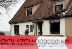 Teilweise ausgebrannt ist dieses Haus, vor dem ein Polizeibeamter der Spurensicherung am Montag (15. November 2004) in Bomlitz (Kreis Soltau-Fallingbostel) steht. (Foto: dpa)