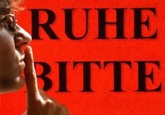 «Ruhe bitte» - vor einem Hinweisschild hält sich eine Frau den Finger vor ihren Mund. (Foto: dpa)