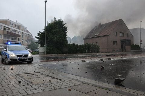 Ein Polizeiauto steht vor einem am Sonntag teilweise eingestürzten Wohnhaus in Bielefeld. Mehrere Explosionen in dem Bielefelder Haus haben fünf Menschen schwer verletzt. (FOTO: DPA)
