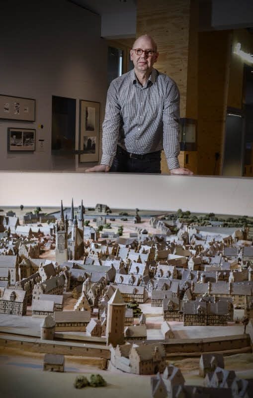 Christian Feigel steht im Stadtmuseum hinter einem imposanten Modell der Stadt Halle.