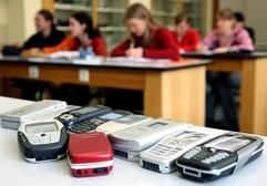 Schülerinnen verfolgen am Mittwoch (29.03.2006) den Unterricht im Caspar-Vischer-Gymnasium in Kulmbach. Im Vordergrund liegen ihre Handys auf einem Tisch (Illustration zum Thema «Handy-Nutzungsverbot an Bayerns Schulen»). Das bayerische Kabinett hat am Dienstag (28.03.2006) ein Nutzungsverbot für Handys an Schulen festgelegt. (Foto: dpa)