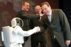 Vor Beginn der offiziellen Eröffnung der Hannover Messe Industrie wird Bundeskanzler Gerhard Schröder (r, SPD), im Beisein von Michael Rogowski, Präsident des Bundesverbandes der Deutschen Industrie (l, BDI) und Hannovers Oberbürgermeister Herbert Schmalstieg von Roboter "Asimo" am Sonntag (18.04.2004) im Kuppelsaal der Stadhalle in der niedersächsischen Landeshauptstadt begrüßt. (Foto: dpa)