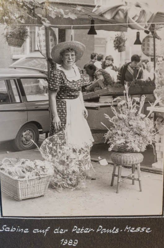 Im Fotoalbum geblättert: Sabine Henschke während ihrer Ausbildung zur Blumenbinderin, mit ihren Eltern zur Eröffnung der Filiale in der Jenaer Straße 1994 sowie auf der Peter-Pauls-Messe 1989.