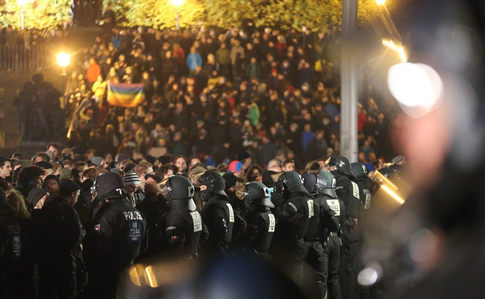 Demonstranten gegen Pegida stehen in der Altstadt in Dresden hinter einer Kette aus Polizeibeamten.