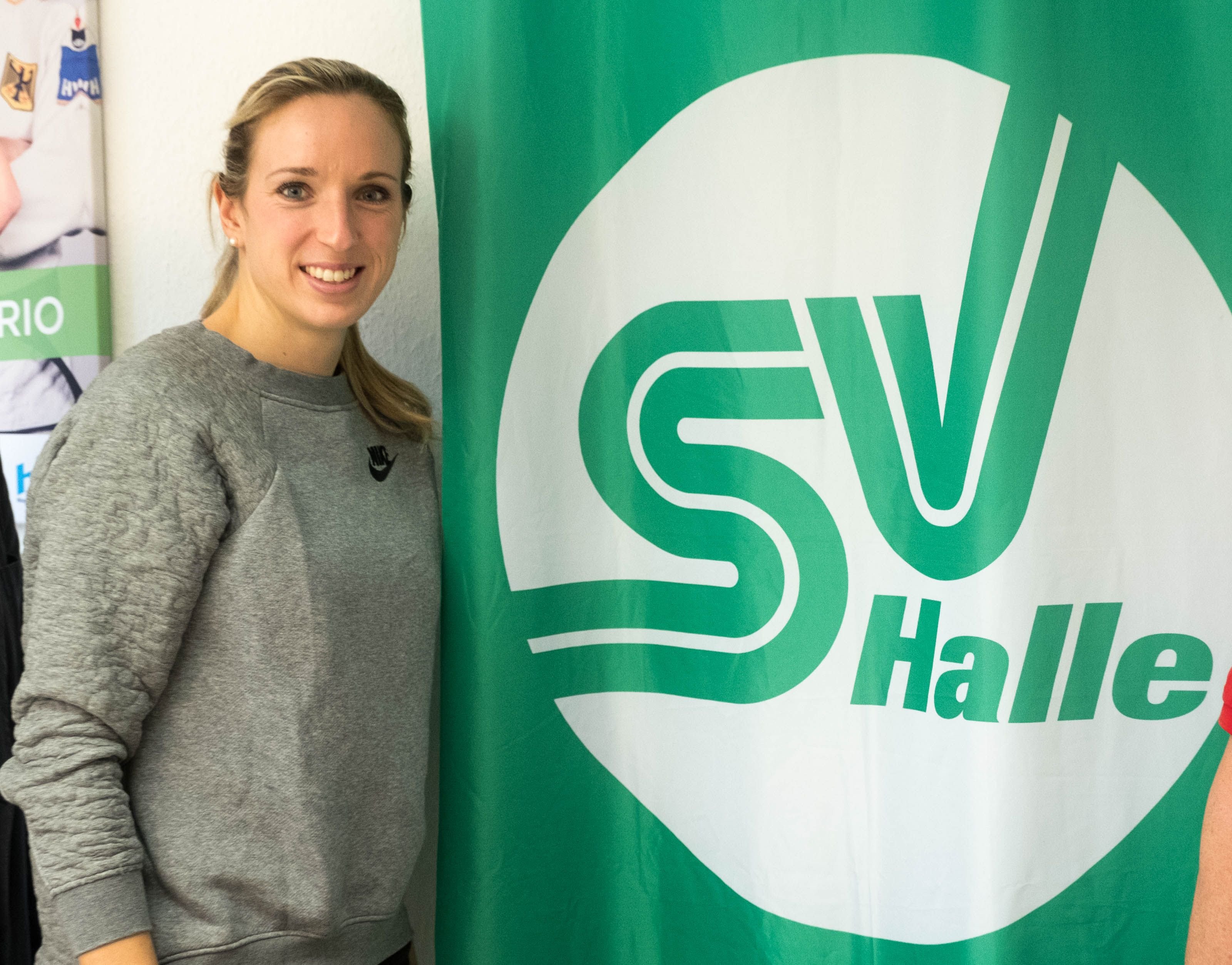 Hürdensprinterin Cindy Roleder vor dem Logo des SV Halle.