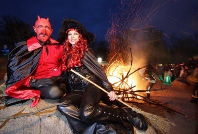 Als Teufel und Hexe verkleidet sitzen ein Mann und eine Frau während der Walpurgisnacht auf einem Stein auf dem Hexentanzplatz in Thale (Landkreis Harz). (FOTO: DPA)