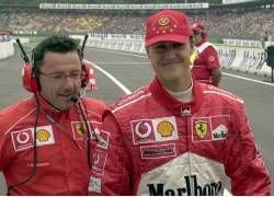 Formel 1-Weltmeister Michael Schumacher (r, Ferrari) läuft am Freitag (26.07.2002) beim Freien Training auf dem Hockenheimring mit seinem Renningeneur Luca Baldessari (l) zu seinem Wagen. Am Sonntag (28.07.2002) startet auf der neu gestalteten Strecke in Hockenheim der Große Preis von Deutschland. dpa/lsw