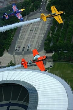 Die Piloten Peter Besenyei aus Ungarn (blaues Flugzeug), Klaus Schrodt aus Berlin (gelb) und Nicolas Ivanoff aus Frankreich (rot) fliegen am Donnerstag (25.05.2006) in Berlin über das Olympia-Stadion. (Foto: dpa)