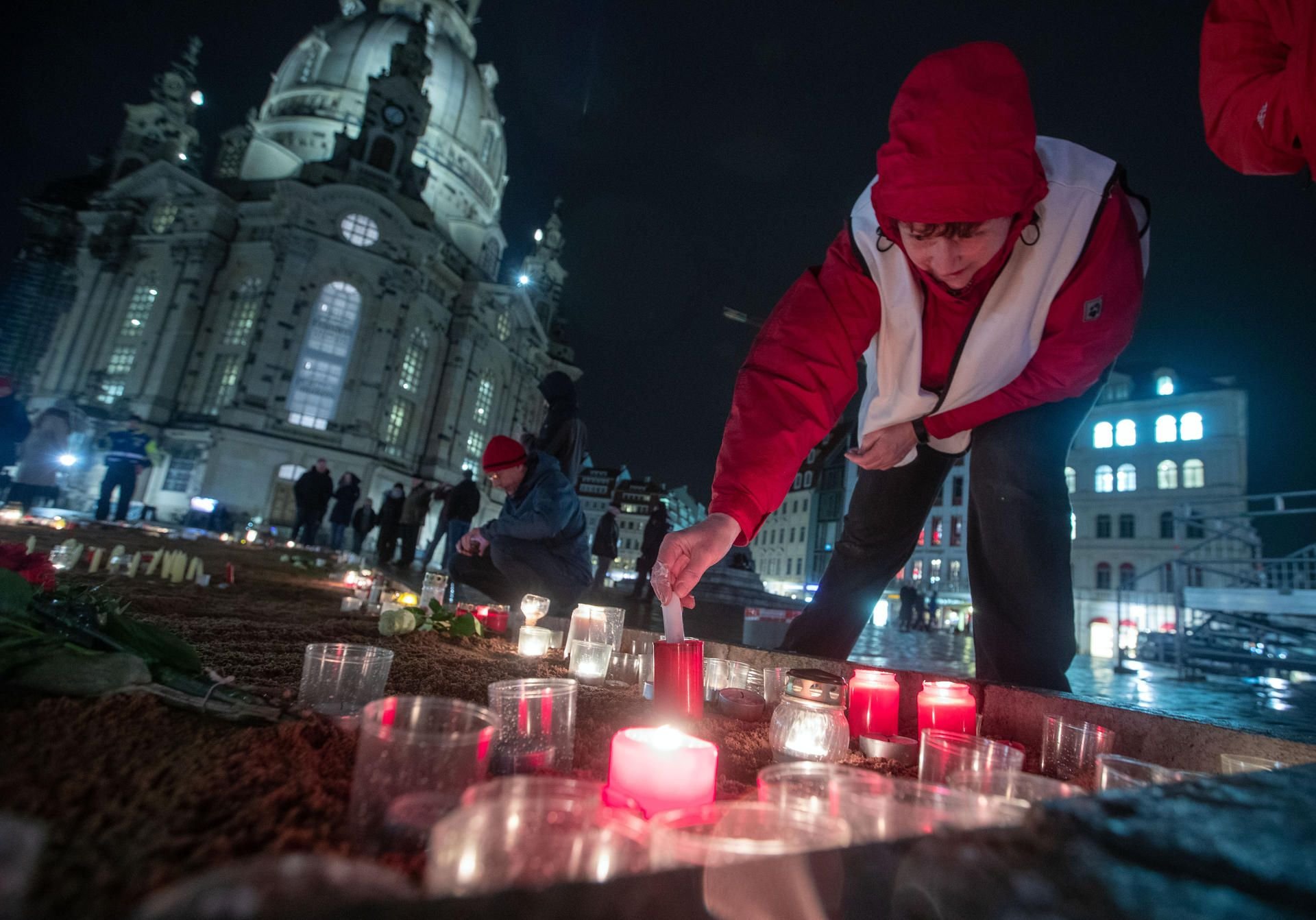 Dresden: Brigitte Funk stellt vor der Frauenkirche Kerzen auf.