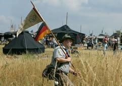 Der Pfadfinder Jaan Weber aus Ruthweiler (Rheinland-Pfalz) geht im nordbrandenburgischen Großzerlang nahe Rheinsberg (Ostprignitz-Ruppin) durch die Zeltstadt des Pfadfindertreffes. (Foto: dpa)