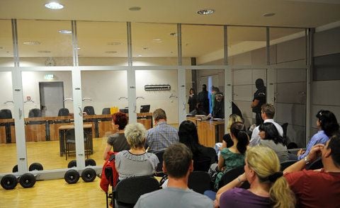 Zuschauer im Prozess gegen ein mutmaßliches Mitglied des Motorradclubs «Bandidos» sitzen am Donnerstag im Landgericht Halle (Saale) hinter einer Panzerglasscheibe. (FOTO: DPA)