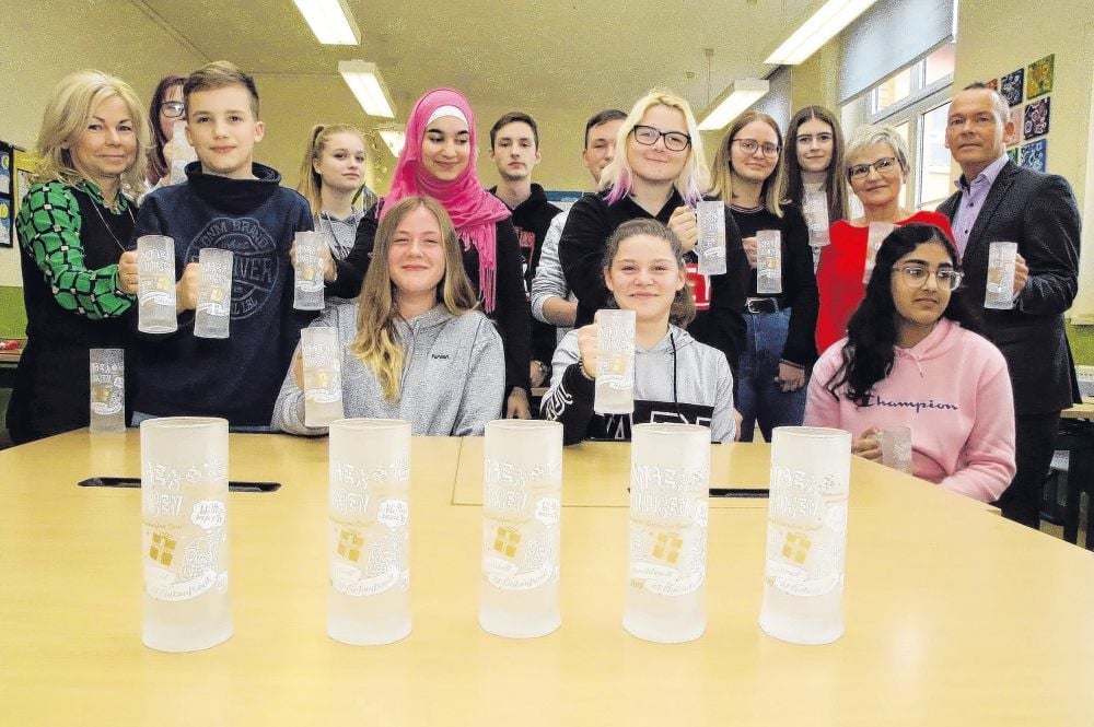 "Advent in den Rosenhöfen" in Sangerhausen: Kunsterziehungslehrerin Birgit Bergmann (hi., 2. v. r.), Christina Griesing (li.), Daniel Schaube und die Müntzer-Schüler mit dem Glühweinseidel 2019