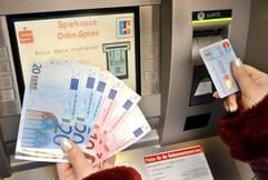Das Archivbild vom 01.01.2002 zeigt eine Frau, die mit ihrer EC-Karte Euro-Banknoten an einem Geldautomaten abhebt. Banken bieten die neue einheitliche Rufnummer 116 116 zum Sperren von EC-Karten an. (Foto: dpa)