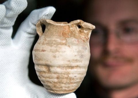 Der Wissenschaftler Dirk Scheidemantel vom Landesamt für Archäologie Sachsen zeigt in Leipzig ein 800 Jahre altes Tongefäß, das bei Ausgrabungen in Heuersdorf gefunden wurde. (FOTO: DPA)