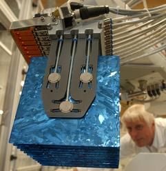 Ein Anlagenfahrer kontrolliert in der Q Cells AG in Thalheim bei Wolfen Solarzellen, die an einem Beladeroboter mit Siliziumnitrit beschichtet werden. (Foto: dpa)