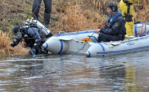 Ein Taucher der Polizei steigt am Montag auf der Suche nach einer Wasserleiche in die Mulde bei Eilenburg. (FOTO: DPA)