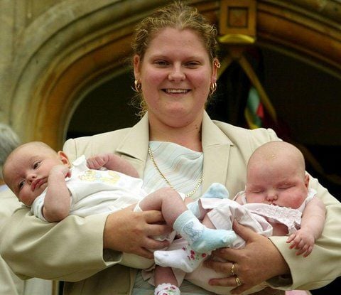Louise Brown, die als weltweit erstes Retortenbaby berühmt wurde, hält am 26.07.2003, an ihrem 25. Geburtstag, die Babys Henry (l.) und Antonia Veary im Arm. (FOTO: DPA)