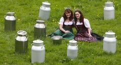 Die Bayerische Milchkönigin Christa Rappensperger (l) aus Erharting (Oberbayern) und die Bayerische Milchprinzessin Martina Hartmann aus Betzigau (Allgäu) sitzen am Dienstag (08.05.2007) zusammen auf einer Kälberwiese in der Ortschaft Ettal (Oberbayern) zwischen lauter Milchkannen. (Foto: dpa)