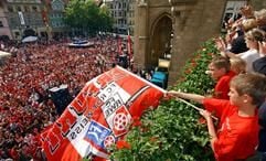 Spieler des FC Rot-Weiß Erfurt und Spielerfrauen und Kinder jubeln am Sonntag (6. Juni 2004) nach dem Aufstieg in die 2. Bundesliga von einem Balkon des Rathauses in Erfurt den Fans zu. (Foto: dpa)