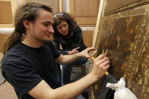 Maik Sommerfeld, der ein Freiwilliges Jahr in der Denkmalpflege absolviert, zeigt Geschäftsführerin Claudia Hennrich, wie die Türen für den Schlossberg 11 nach der Restaurierung aussehen werden. (FOTO: CHRIS WOHLFELD)
