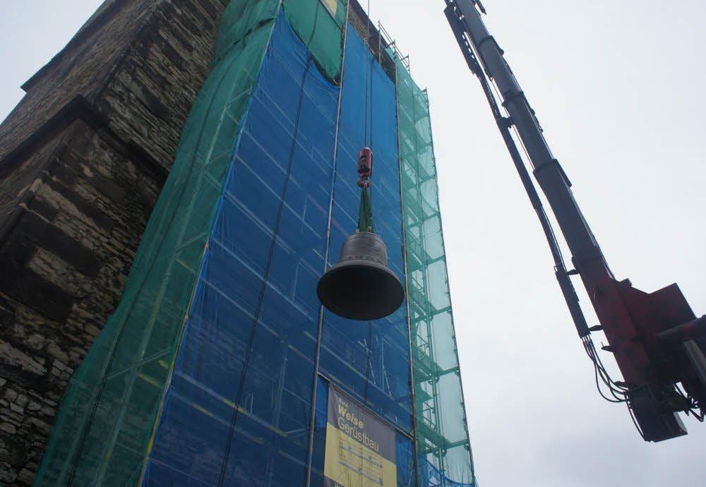 Eine der Glocken wird in den Turm gehoben.