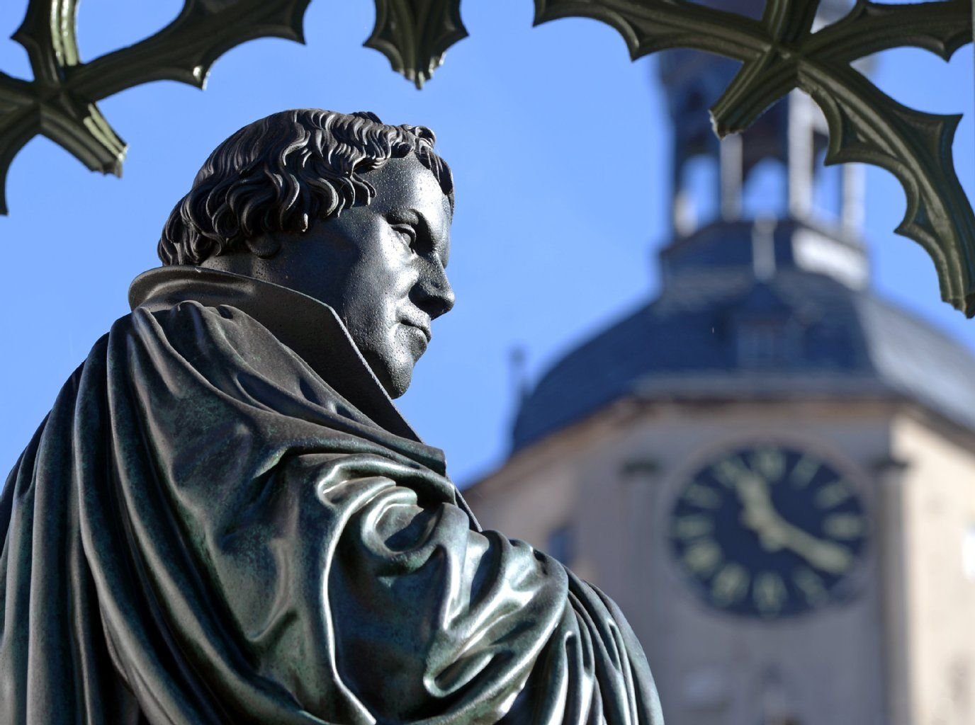 Ein Denkmal an den Reformator Martin Luther steht vor dem Turm der Stadtkirche in Wittenberg