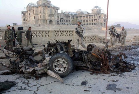 Afghanische und US-Soldaten untersuchen die Überreste eines Autos nach eines Selbstmordattentat in Kabul.