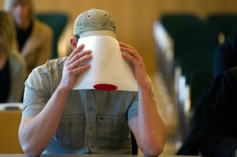 Der Angeklagte Marco C. hält sich am 8. März 2011 zu Beginn des Prozesses im Landgericht in Dresden eine Broschüre vor das Gesicht. Den fünf Mitglieder der verbotenen Neonazi-Gruppe «Sturm 34» wird Bildung einer kriminellen Vereinigung und gefährliche Körperverletzung vorgeworfen. (FOTO: DPA)