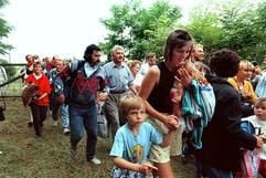 DDR-Flüchtlinge mit ihren Kindern gehen durch das geöffnete Grenztor von Ungarn aus nach Österreich (Archivbild vom 19. August 1989). Sie nutzten damals ein paneuropäisches Picknick an der ungarisch-österreichischen Grenze, bei dem ein Grenztor symbolisch geöffnet wurde, zur Flucht in den Westen. (Foto: dpa)