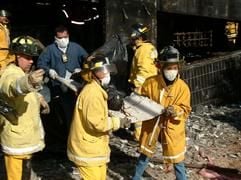 Feuerwehrmänner bergen nach dem Brand in einem Einkaufszentrum in Paraguays Hauptstadt Asunción einen Schwerverletzten. (Foto: dpa)