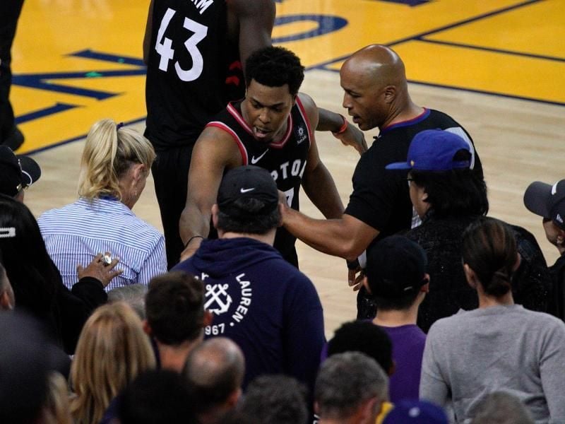 Kyle Lowry (M) von den Toronto Raptors beschwert sich neben Schiedsrichter Marc Davis über einen Fan. Foto: Tony Avelar/FR155217 AP/
