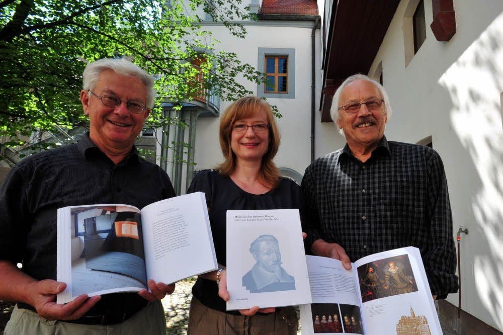 Der Katalog hat viele Gesichter: Johannes Kreis, Henrike Rucker und Otto Klein (von links) zeigen ihn druckfrisch im Hof des Schützhauses.