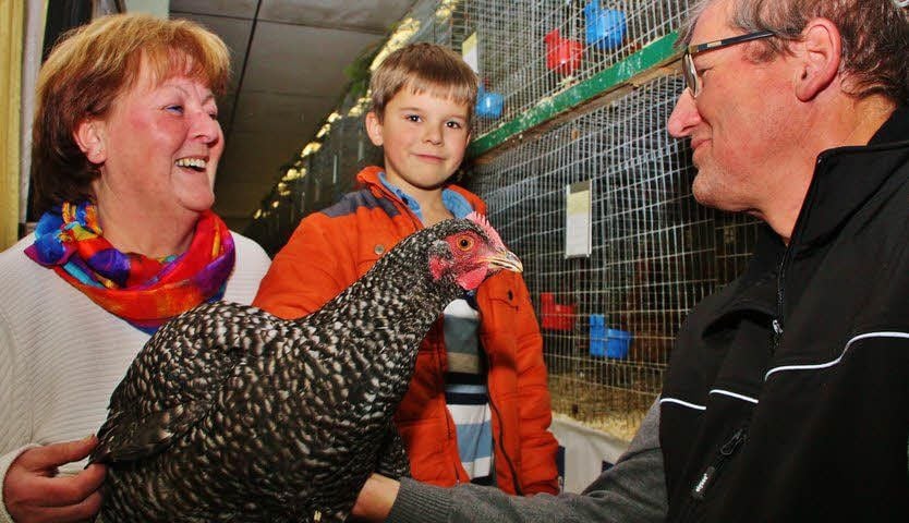 Monika Stockhaus und Enkel Marcus staunen über das große Mechelner-Huhn, das ihnen Vereinschef Hans-Joachim Brekau zeigt.