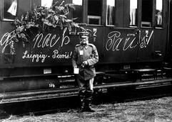 Ein 70-jähriger Freiwilliger steht im August 1914 in Leipzig neben einem geschmückten Zug mit der Aufschrift «nach Paris!», der Truppen an die Westfront bringen soll. (Archivfoto: dpa)