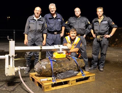 Burhard Mantsch, Hermann Borelli, Peter Bodes, Michael Hein und Andre Kowalzik vom Kampfmittelräumdienst stehen in Hamburg an einer Fliegerbombe, die sie in der Nacht entschärft hatten. (FOTO: DPA)