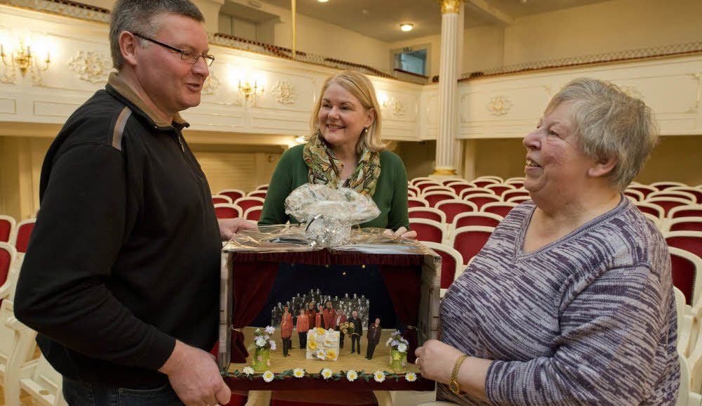 Nach über 60 Jahren am Schlosstheater wurde Ursula Preuß (r.) verabschiedet. Bettina Fügemann und Bühnenmeister Uwe Severin überreichten ihr ein Bühnenmodell mit allen Mitarbeitern, das das Einlassteam des Hauses und Uwe Severin gebastelt haben.