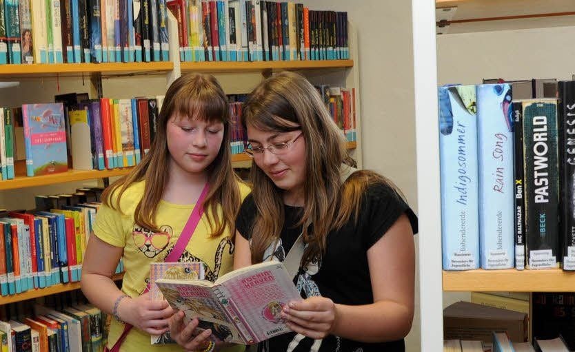 Leonie (l.) und Jasmin inmitten der Schätze der Bibliothek.