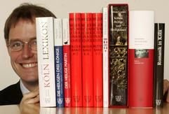Damian van Melis, Geschäftsführer des Greven Verlags, blickt am Dienstag (21.06.2005) in Köln an einigen Büchern vorbei, die aus seinem Verlag stammen. (Foto: dpa)
