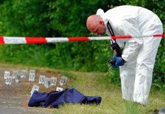 Ein Kriminalbeamter sichert Spuren hinter einer Polizeiabsperrung in Bayreuth (Oberfranken). Bei einer Schießerei in Bayreuth ist am Sonntag ein 53 Jahre alter Mann getötet und ein Polizist schwer verletzt worden. (Foto: dpa)