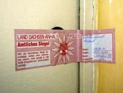 Blick auf eine versiegelte Wohnung am Donnerstag (08.04.2004) in einer Plattenbausiedlung in Staßfurt, in der am Morgen eine Mutter ihren sieben Jahre alten Sohn mit einem Messer erstochen hatte. Die 34-Jährige rammte ihrem Sohn nach Polizeiangaben ein Messer in die Brust. Der Junge kam auf die Intensivstation des Krankenhauses Aschersleben, wo er etwa zwei Stunden später starb. Nach Angaben von Nachbarn wohnte die Mutter dort mit drei Kindern. Viele Menschen in der 25 Kilometer südlich von Magdeburg gelegenen Stadt reagierten fassungslos und entsetzt auf das Verbrechen. (Foto: dpa)